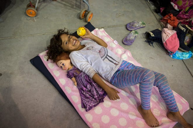 A girl relaxes next to her doll inside a temporary shelter set up for a splinter group of a migrant caravan hoping to reach the U.S. border, in Cordoba, Veracruz state, Mexico, Sunday, Nov. 4, 2018. Thousands of wary Central American migrants resumed their push toward the United States on Sunday, entering a treacherous part of the caravan’s journey on a trek through one of Mexico’s deadliest states, along what some called the “route of death” toward the town of Cordoba, Veracruz. (AP Photo/Rodrigo Abd)