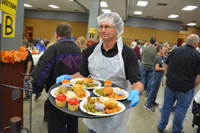 Dennis Frazee delivers meals to diners at the 50th annual Community Thanksgiving Dinner at Ag Hall last year. [2017 file photo/The Capital-Journal]