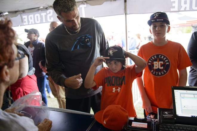 Trace Fowler, 9, tries on a Woodpeckers hat while shopping with his dad, Wes, left, and brother Alex, 13, on Sunday. The new team name was revealed during a launch party in Festival Park. [Melissa Sue Gerrits/The Fayetteville Observer]