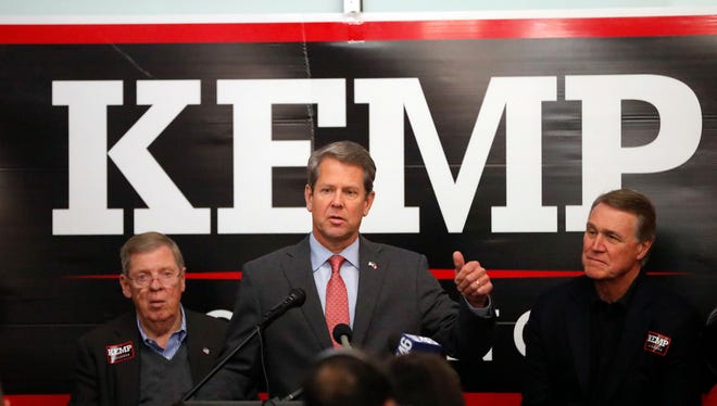 Georgia Republican gubernatorial candidate Brian Kemp, center, speaks to volunteers as Sen. Johnny Isakson (R-Ga), left, and Sen David Perdue (R-Ga) looks on during a stop at a campaign office Monday, Nov. 5, 2018, in Atlanta. Kemp is in a close race with Democrat Stacey Abrams. (AP Photo/John Bazemore)
