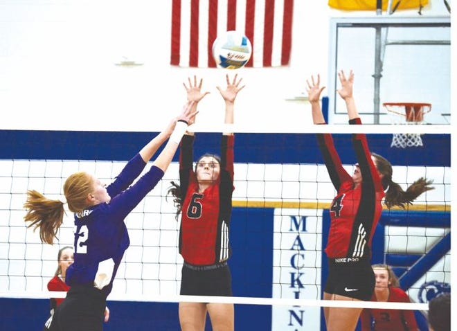 Onaway's Malaurie McLean (middle) and Calley Selke (right) go up to block a kill attempt from Pickford's Darcy Bennin (left) during the first set of a MHSAA Division 4 regional volleyball semifinal in Mackinaw City on Tuesday.