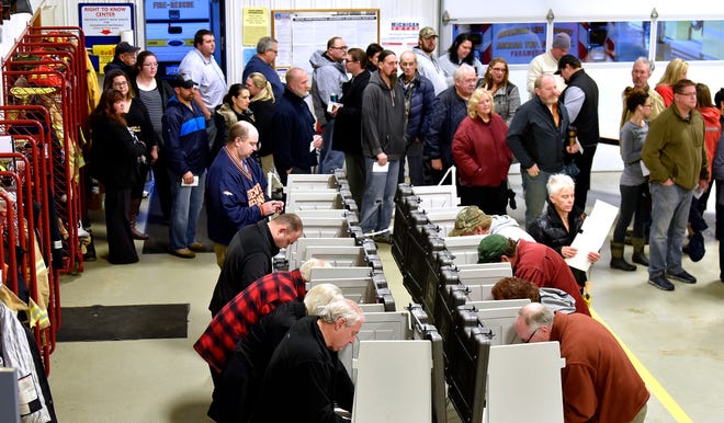 Voters wait on line to vote inside the fire bay at the Armada Twp. Fire Department, Tuesday , Nov. 6, 2018, in Armada Twp, Mich. (Todd McInturf /Detroit News via AP)
