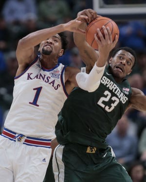 Kansas forward Dedric Lawson (1) fights for a rebound with Michigan State forward Xavier Tillman (23) during the first half of an NCAA college basketball game at the Champions Classic in Indianapolis on Tuesday, Nov. 6, 2018. (AP Photo/AJ Mast)