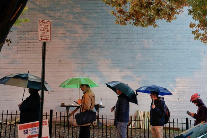 Voters line up in the rain outside Bright Family and Youth Center in the Columbia Heights neighborhood in Washington, Tuesday, Nov. 6, 2018. Across the country, voters headed to the polls Tuesday in one of the most high-profile midterm elections in years. (AP Photo/Pablo Martinez Monsivais)