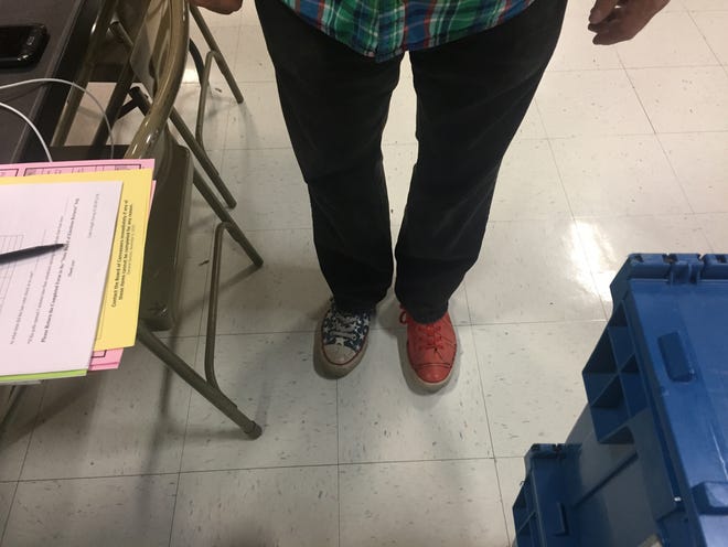 Poll clerk Peter Stetson has a foot in each political camp on Election Day: Red and blue sneakers. [The Providence Journal / Donita Naylor]