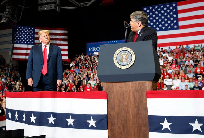 President Donald Trump listens Fox News' Sean Hannity speak during a rally at Show Me Center, Monday, Nov. 5, 2018, in Cape Girardeau, Mo..
