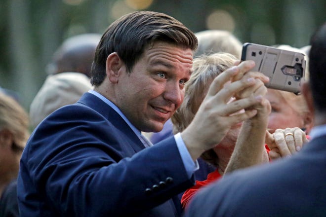 Republican gubernatorial candidate Ron DeSantis takes a selfie with one of his supporters during a rally on the final day of early voting, Sunday, in Boca Raton. [FILE/THE ASSOCIATED PRESS]