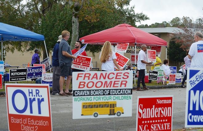 Campaign supporters speak with voters in the H.J. McDonald Middle School parking lot Tuesday morning. [TODD WETHERINGTON / SUN JOURNAL STAFF]