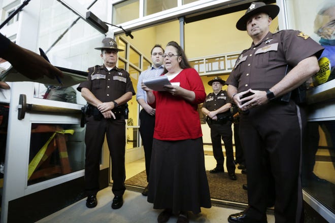Rowan County Clerk Kim Davis, with son Nathan Davis, a deputy clerk, reads a statement to the media outside the Rowan County Courthouse in Morehead, Ky., on September 14, 2015. [Pablo Alcala/Lexington Herald-Leader/TNS]