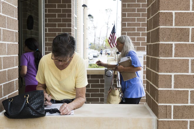 Darlene Holland fills out a sample ballot in front of the supervisor of elections office mega voting site in Panama City, Florida on Tuesday, November 6, 2018. "With all the storm stuff going on, I haven't been able to inquire about it all. Like everyone else," she says while trying to parse the language of constitutional amendments on the ballot. [JOSHUA BOUCHER/THE NEWS HERALD]