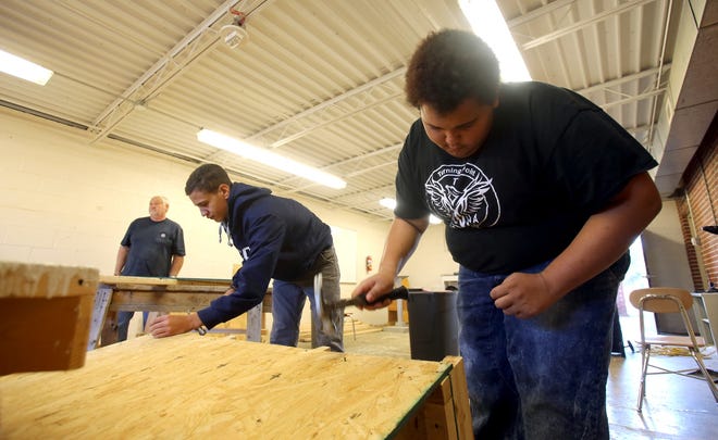 From left, Isaiah Mellon and Justin Camp construct a doghouse at Turning Point Academy on Wednesday. [Brittany Randolph/The Star]
