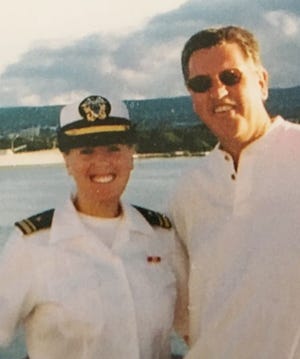 Courtney Hatchel and her father, Chuck Blake, pose for a picture on a ship while Hatchel was still in the Navy