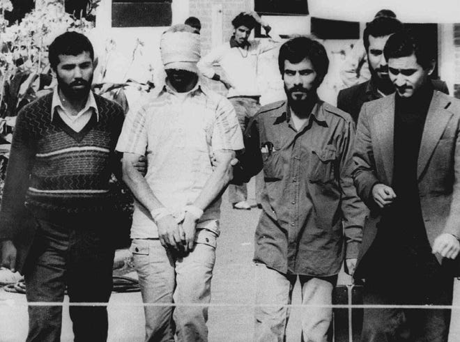 One of 66 American hostages - blindfolded with his hands bound - is displayed to the crowd outside the U.S. embassy in Tehran on Nov. 9, 1979. Their captors held 52 of the Americans for 444 days. [The Associated Press]