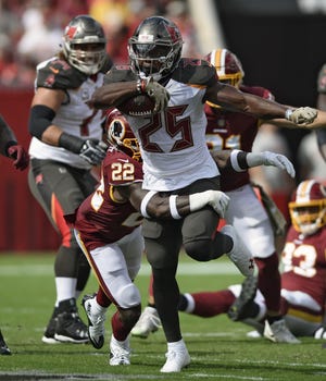 Tampa Bay Buccaneers running back Peyton Barber (25) tries to break a tackle by Washington Redskins defensive back Deshazor Everett (22) during the first half of an NFL football game Sunday, Nov. 11, 2018, in Tampa, Fla. (AP Photo/Jason Behnken)