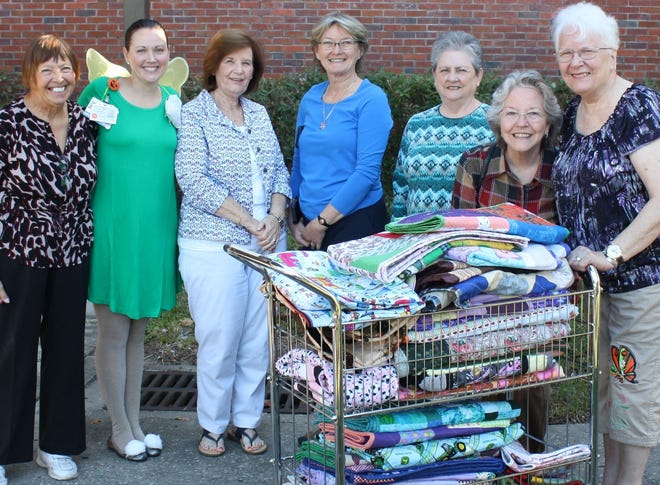 Morriston Baptist Church quilters and their recent donation of about 30 quilts to the UF Health Shands Hospital Children’s Intensive Care Unit. From left, Linda Hall; Brianna Kear, social worker for the unit (dressed as a pixie for halloween); Pat Stephens; Diane Howard, social worker for the unit; Barbara Henson; Fay Vause; and Laura Fisher. [Submitted photo]
