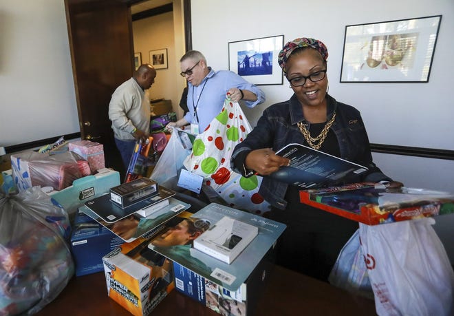 Nikita Tookes, right, Anthony Sommer and Cleveland Wester, left, of Community Partners pick up toys and other donations from the annual holiday toy drive at the Palm Beach Daily News in December 2017. [Bruce R. Bennett/palmbeachdailynews.com]