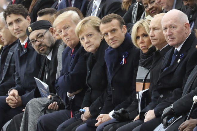 Canadian Prime Minister Justin Trudeau, left, Morocco's Prince Moulay Hassan, Moroccan King Mohammed VI, US First Lady Melania Trump, US President Donald Trump, German Chancellor Angela Merkel, French President Emmanuel Macron and his wife Brigitte Macron, Russian President Vladimir Putin and Australian Governor-General Peter Cosgrove attend a ceremony the Arc de Triomphe in Paris, France, as part of the commemorations marking the 100th anniversary of the 11 November 1918 armistice, ending World War I, Sunday, Nov. 11, 2018. [Ludovic Marin/Pool Photo via AP]