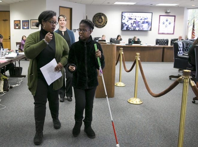 Gabby Caldwell, 17, who is deaf and blind, and her mother, Robbie Caldwell, walk away from the podium after they spoke in favor of keeping Helen Keller in the Texas social studies curriculum at the State Board of Education meeting in Austin on Tuesday. [JAY JANNER/AMERICAN-STATESMAN]