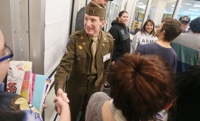 U.S. Army veteran Frank Klansek, 90, who served in Japan in 1946-47 shakes hands with Coventry High School seniors on Monday after a breakfast for veterans. [Mike Cardew/Beacon Journal/Ohio.com]