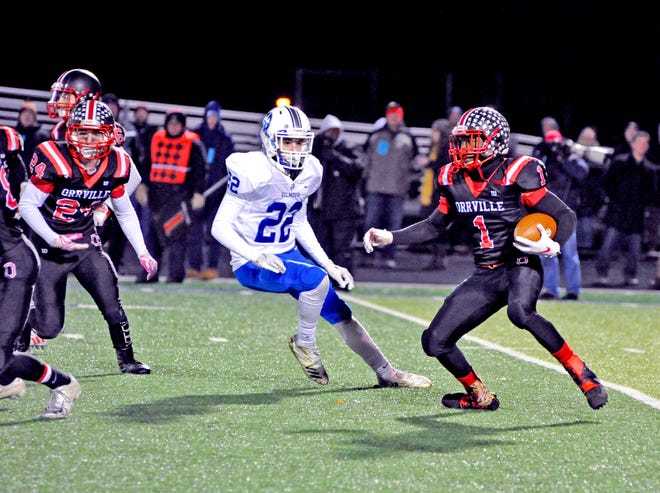 Orrville's Marquael Parks evades Gilmour Academy's Nathan Reichard while carrying the ball during Saturday's Div. V regional semifinal game in Twinsburg. Parks rushed for 207 yards and four touchdowns in the Red Riders' 50-43 triple-overtime victory over the Lancers.