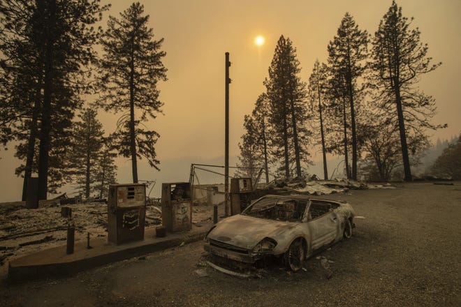As the Camp Fire burns nearby, a scorched car rests by gas pumps near Pulga, Calif., on Sunday. [AP PHOTO/NOAH BERGER]