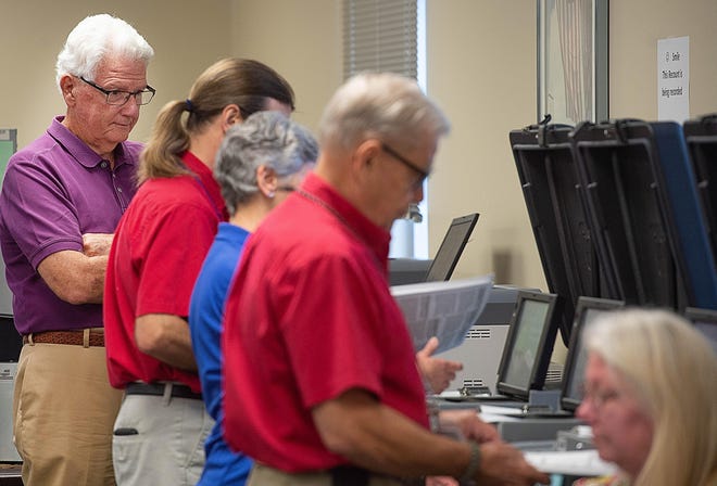 County election canvasing board member Ron Brown, left, watches as elections officials test voting machines at the St. Johns County Supervisor of Elections office in St. Augustine during the general election recount on Monday. [PETER WILLOTT/THE RECORD]