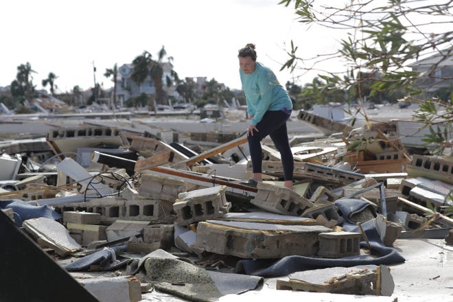 A woman digs through the rubble of her home in Mexico Beach, which was destroyed by Hurricane Michael. [AP Photo/Gerald Herbert/File]