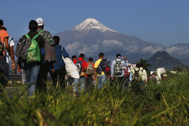Central American migrants begin their morning trek as part of a thousands-strong caravan hoping to reach the U.S. border, as they face the Pico de Orizaba volcano in Mexico on Nov. 5. [AP Photo/Marco Ugarte, File]