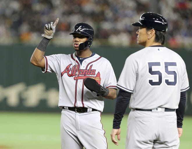 MLB All-Star Ronald Acuna Jr. of the Atlanta Braves points to the ceiling while talking with first base coach Hideki Matsui (55) during Game 3 against All Japan at the All-Stars Series at Tokyo Dome in Tokyo on Sunday. [Toru Takahashi/Associated Press]