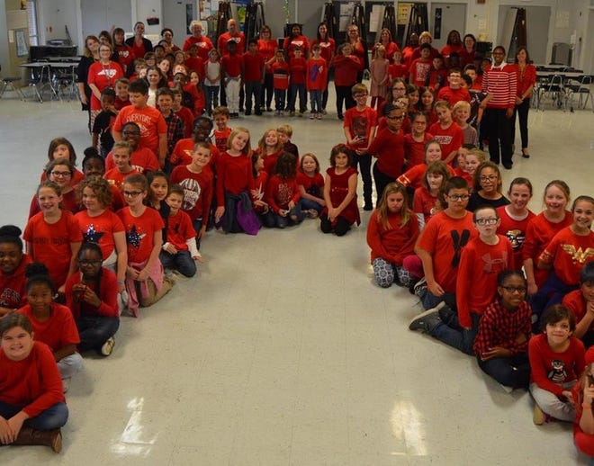 Students and staff who wore red posed as a giant red ribbon for National Red Ribbon Week. [CONTRIBUTED PHOTO]