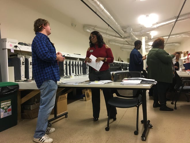 Athens-Clarke County Board of Elections member Jesse Evans (left) discusses the recanvassing process with ACC Director of Elections and Voter Registration Charlotte Sosebee. On Tuesday, Nov. 13, 2018, the poll workers and elections staff shown behind them had to feed every ACC paper ballot — about 3,000 — through scanners one at a time. [Photo by Sierra Runnels for the Athens Banner-Herald]