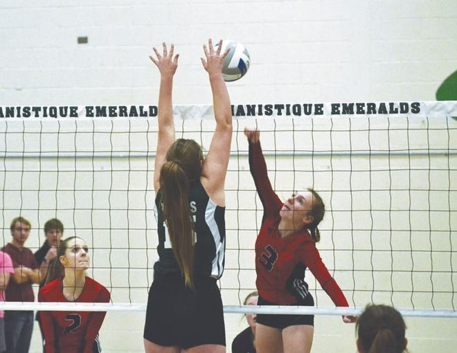 Onaway senior Kennedy Crawford (3) attempts to strike the ball past a blocking Ashlyn Hansen (15) of Carney-Nadeau during the second set of a MHSAA Division 4 volleyball quarterfinal in Manistique on Tuesday.
