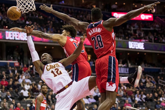 Cleveland Cavaliers guard David Nwaba (12) tries to shoot past Washington Wizards forward Kelly Oubre Jr. (12) and center Ian Mahinmi (28), from France, during the first half of an NBA basketball game Wednesday, Nov. 14, 2018, in Washington. (AP Photo/Alex Brandon)