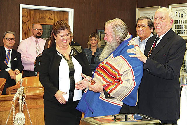 The Osage Nation honored retiring Associate District Judge B. David Gambill, of Pawhuska, with a ceremonial blanket and a gavel during a retirement occasion held Friday, Nov. 9, at the Osage County Courthouse. Gambill reaches to shake hands with Amanda Proctor as Ed Red Eagle (back) and Gene Dennison, right, look on.