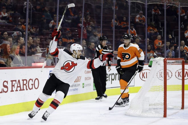The Devils' Blake Coleman celebrates a goal by teammate Joey Anderson in front of the Flyers' Christian Folin during Thursday's game. [MATT SLOCUM/ASSOCIATED PRESS]