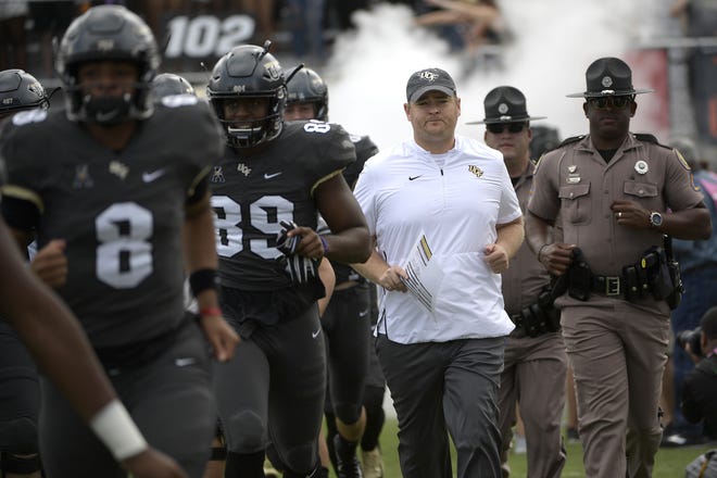 Central Florida head coach Josh Heupel, center, runs onto the field with the team before a game against Navy last week in Orlando. [AP Photo/Phelan M. Ebenhack, File]