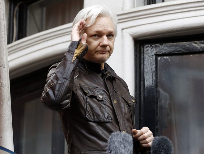 In this May 19, 2017, file photo, WikiLeaks founder Julian Assange greets supporters from a balcony of the Ecuadorian embassy in London. Assange will not willingly travel to the United States to face charges filed under seal against him, one of his lawyers said Friday, foreshadowing a possible fight over extradition for a central figure in the U.S. special counsel's Russia-Trump investigation. [FRANK AUGSTEIN/ASSOCIATED PRESS]