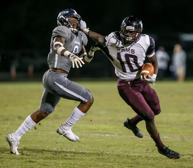 Palm Beach Lakes' Kevon Purnell is called for a face mask penalty as he tries to get away from Dwyer's JoJo Evans, Jr., Friday night at Dwyer High School. [RICHARD GRAULICH/palmbeachpost.com]