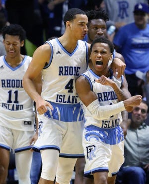 URI's Fatts Russell, right, exults after his 3-point basket with 3.8 seconds gave the Rams a 76-74 win over Harvard on Friday night. Celebrating with him are Tyrese Martin and Jeff Dowtin.