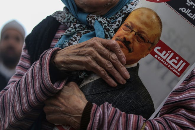 A woman holds a poster during the funeral prayers in absentia for Saudi writer Jamal Khashoggi who was killed last month in the Saudi Arabia consulate Friday in Istanbul. Turkey's Foreign Minister Mevlut Cavusoglu on Thursday called for an international investigation into the killing of the Saudi dissident Jamal Khashoggi. The CIA has concluded Saudi crown prince ordered Khashoggi's assassination. [Emrah Gurel/The Associated Press]
