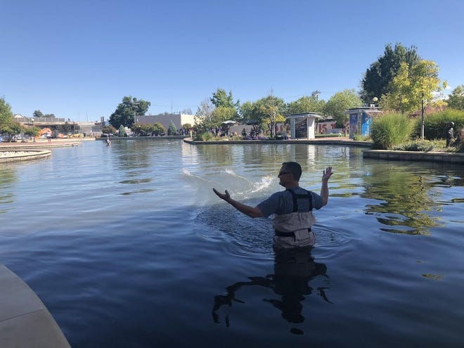 Volunteers with Pueblo Rotary No. 43 stand in the river channel on the Historic Arkansas Riverwalk of Pueblo to retrieve sinking ships of race competitors during the Duck Cup for Dictionaries event in September. [COURTESY PHOTO]