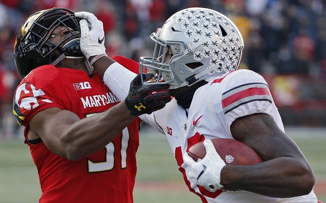 Ohio State tight end Rashod Berry tries to fend off Maryland linebacker Nnamdi Egbuaba after making an 11-yard catch on fourth-and-1 in overtime. [Kyle Robertson/Dispatch]