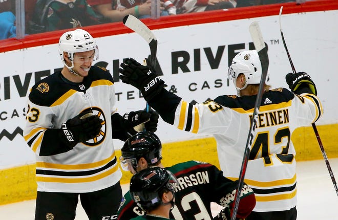 Boston Bruins center Jakob Forsbacka Karlsson (23) celebrates his goal against the Arizona Coyotes with center Danton Heinen (43) during the first period of an NHL hockey game Saturday, Nov. 17, 2018, in Glendale, Ariz. (AP Photo/Ross D. Franklin)