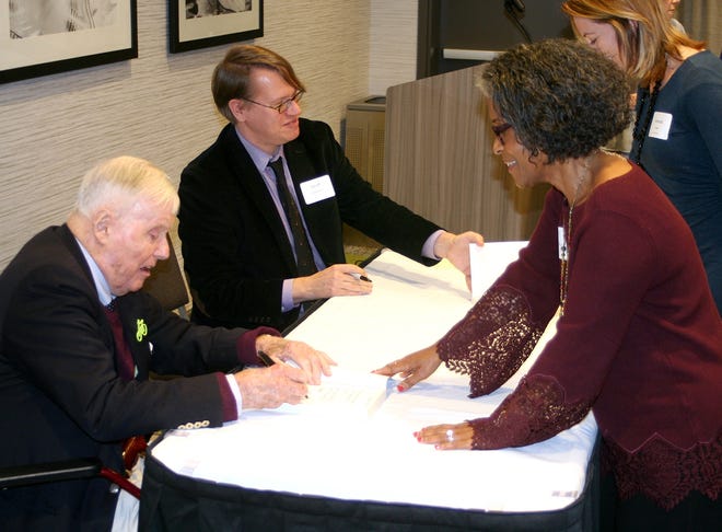 From left, Amo Houghton and author Geoffrey Kabaservice sign copies of the book "The Women of Corning: The Untold Story" Friday at the Hilton Garden Inn in Corning. [SHAWN VARGO/THE LEADER]