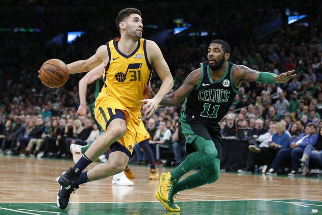 Utah's Georges Niang (left) drives for the basket against the Celtics' Kyrie Irving (right) during the first half of Saturday night's game in Boston. [AP Photo/Michael Dwyer]