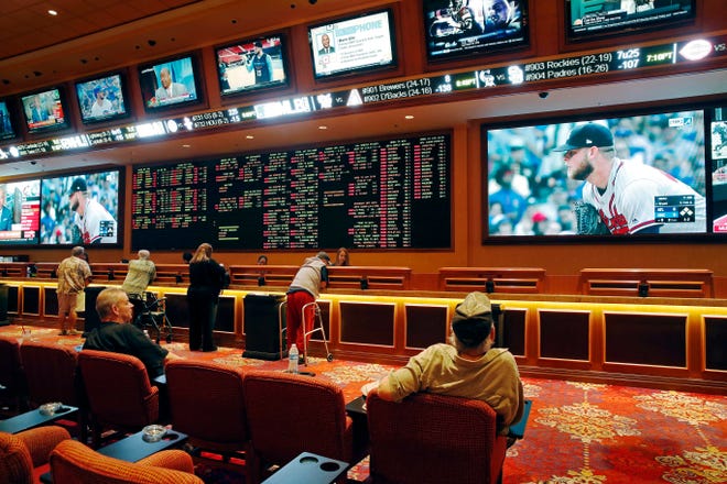FILE – In this May 14, 2018, file photo, people make bets in the sports book at the South Point hotel and casino in Las Vegas. A day before New Jersey’s governor makes his state’s first legal wager on a sporting event, sports betting will be the main topic at a major gambling industry conference in Atlantic City. (AP Photo/John Locher, File)