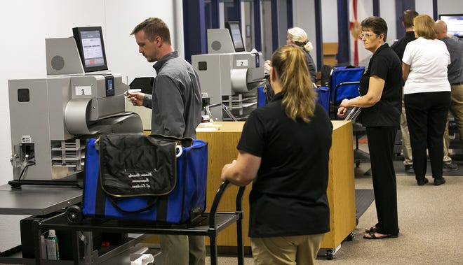 Marion County Supervisor of Elections employees run ballots through three digital scanners during the statewide recount process. [Doug Engle/Ocala Star-Banner]