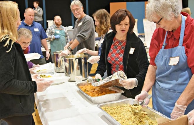 Volunteers form an assembly line at Myrtle Grove Presbyterian Church in 2017, as they do every Thanksgiving, to package 1,000 meals to be delivered. [ASHLEY MORRIS/STARNEWS]