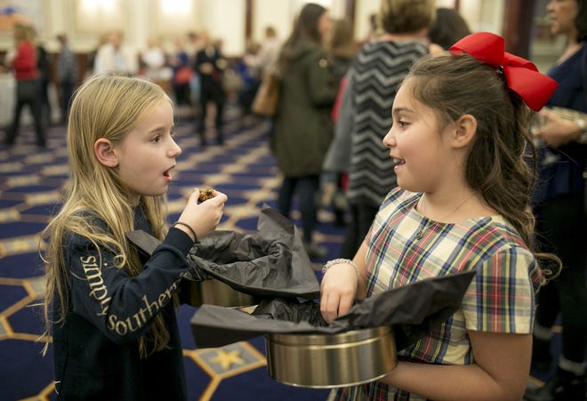 Lexi Amstutz, 8, left, and Cate Lorenz, 9, sample their cookies at the Cookies for Caring event at the Driskill Hotel last year. [JAY JANNER / AMERICAN-STATESMAN]