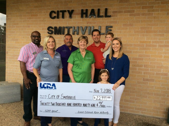 LCRA representatives present a $22,999 grant to the city of Smithville for new playground equipment for three area parks. The grant is part of LCRAís Community Development Partnership Program. Pictured from left to right: Rick Arnic, LCRA governmental affairs representative; Lori A. Berger, LCRA board member; Jack Page, Smithville public works director; Joanna Morgan, Smithville mayor pro tem; Scott Saunders, Smithville mayor, holding Penelope Saunders; Rosaleigh Saunders; and Leah Saunders. [CONTRIBUTED PHOTO]